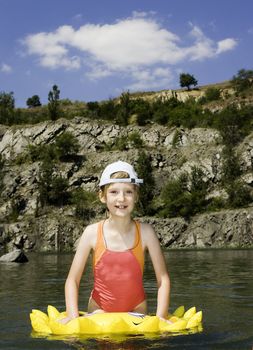 The girl floats on lake with a life buoy