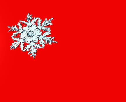 A three-dimensional snow flake on Red.  Designed to be used as a card or poster.