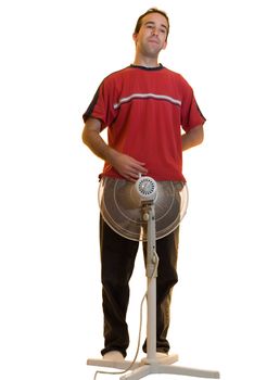 A young man holding his t-shirt over a fan, isolated on a white background