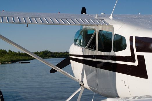 A black and white airplane docked on the water