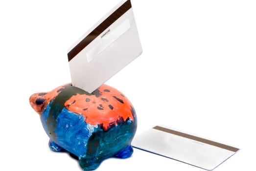 A colorful piggy bank with two bank cards, isolated on a white background