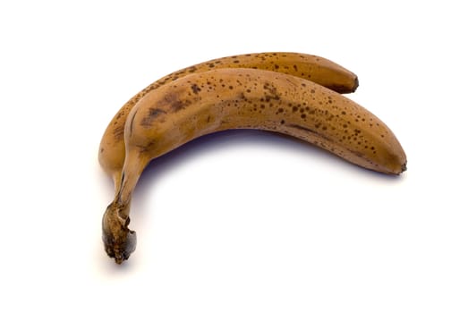 Two frozen brown bananas isolated on a white background