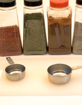 Assortment of spices alond with measuring tools and a cutting board