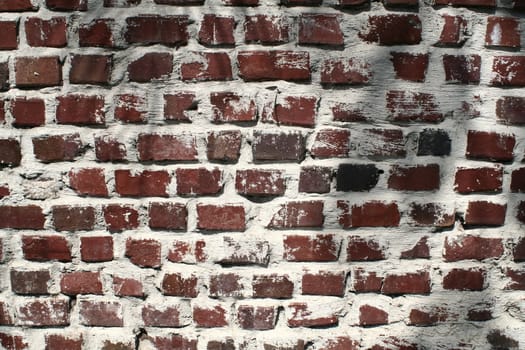A wall of very weathered and aged bricks.