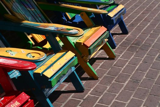 A group of very colorfully painted wooden chairs.