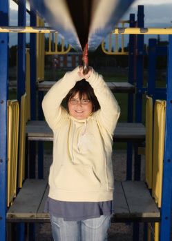 A young girl playing on some playground equipment