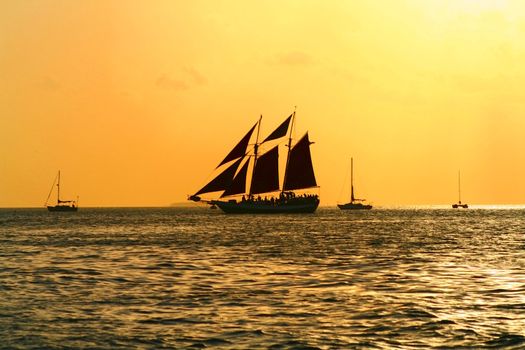 A Sailboat crosses the horizon under the evening sky.