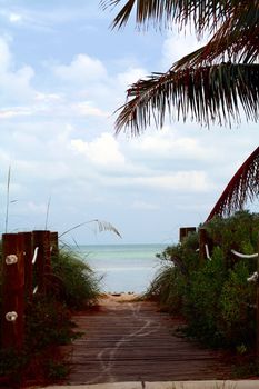 A boardwalk to the beach flanked by nautical line.