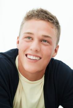 Smiling young blond man loooks up; head and shoulders portrait