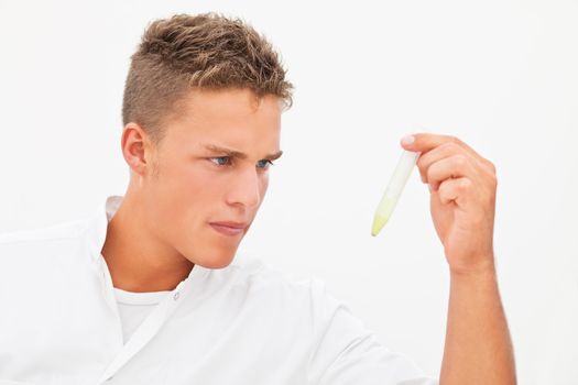 Handsome blond researcher inspecting test result in test-tube; isolated on white