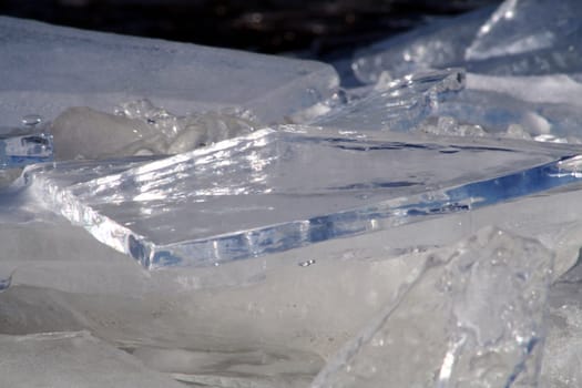 Brocken ice shinning in the winter sun and reflecting the blue sky.