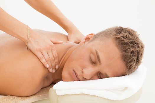 Happy young man enoying massage session in spa resort