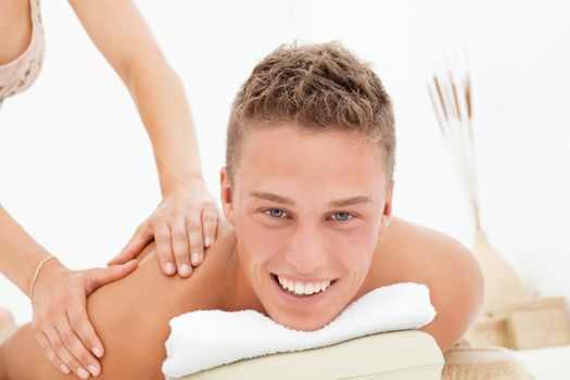 Happy young man enoying massage session in spa resort