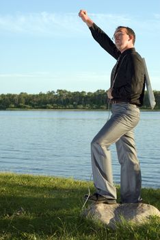 A businessman standing with his fist in the air holding a keyboard