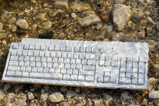 A computer keyboard underwater with bubbles coming up