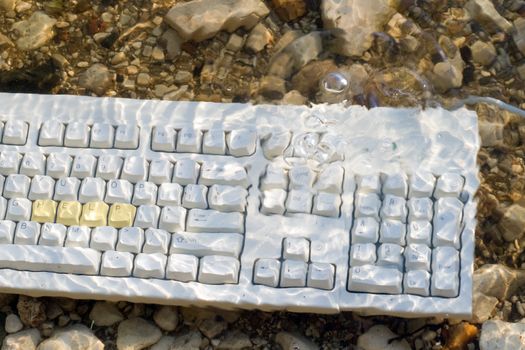 A computer keyboard with the word help underwater