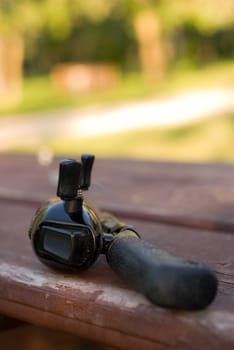 A small fishing rod sitting on a wooden table