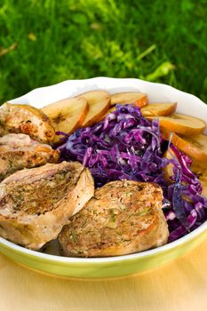 Pork medallions with sliced apples and red cabbage