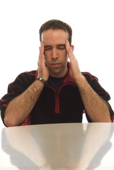 Average looking guy with a massive headache, with his reflection on a table top