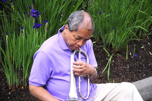 Jazz musician relaxing outdoors in a flower garden.