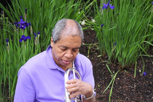 Jazz musician relaxing in a flower garden outdoors.