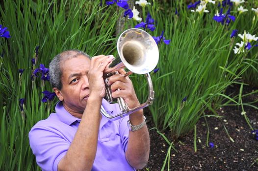 Jazz musician performing outdoors in a flower garden.