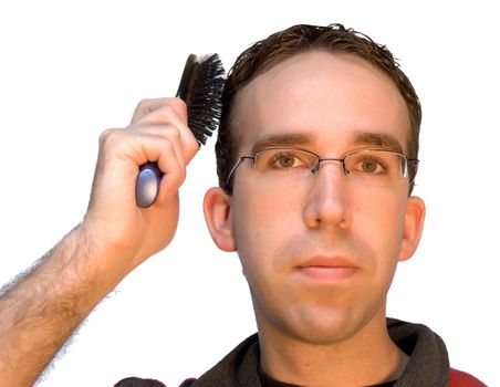 A young caucasian man brushing his hair, isolated against a white background