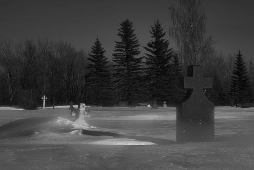 A graveyard at night with some light fog in the air