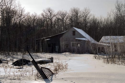 An old haunted house in the middle of winter with junk in the yard