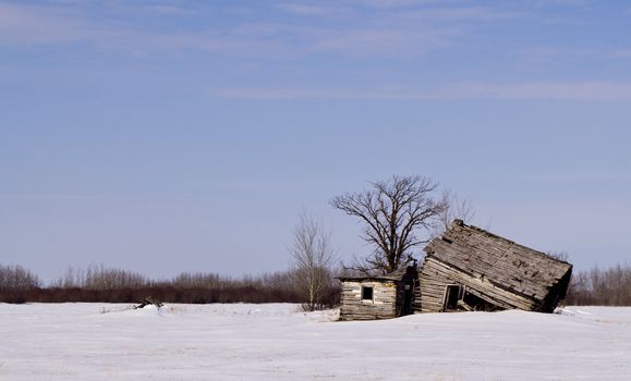 An abandoned house in the middle of a snowy field