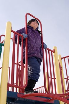 A young girl standing on top of a jungle gym