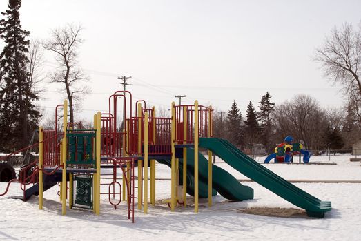 School playground equipment in the middle of winter, with snow on the ground