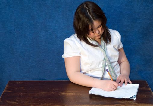 Young girl doing her homework on a wooden table top