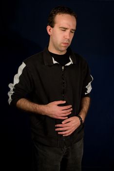 Young male holding his belly because he has an upset stomach
