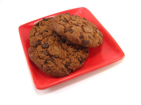some chocolate cookies on a red plate over a white background