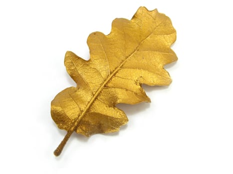 a golden leaf over a white background