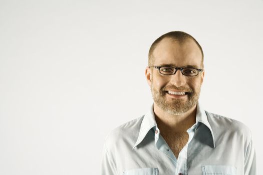 Head and shoulder portrait of Caucasian man smiling against white background.