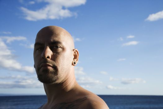 Caucasian prime adult bald male portrait on beach.