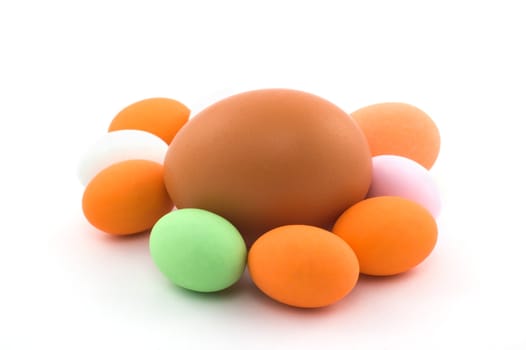 Egg surrounded by little colored Easter eggs on white background