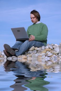 young executive man with laptop on beach