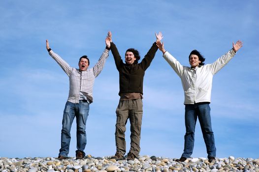 three businessmens with open arms on the beach