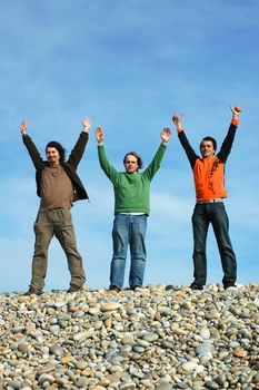 three mens with open arms with the sky as background