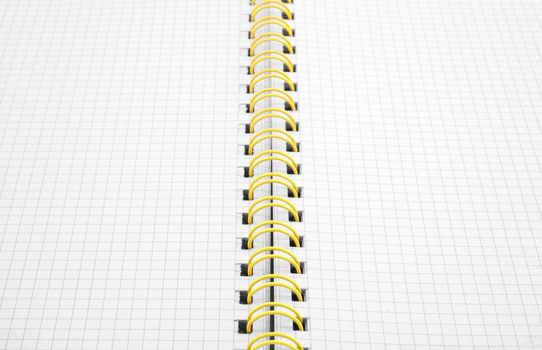 Close up of a spiral bound notebook with yellow spirals