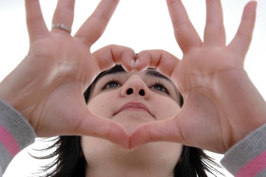 beautiful woman depicts the heart as hands over white background