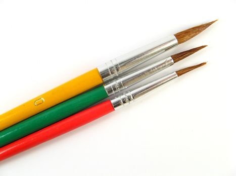 some colored paintbrushes over a white background