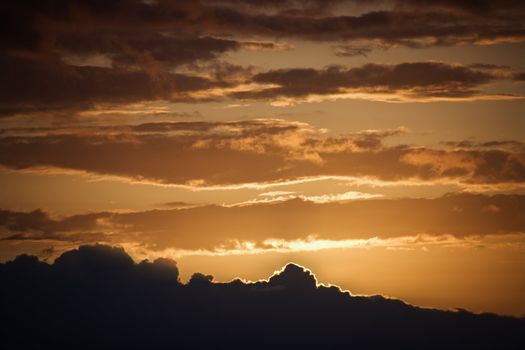 Golden sunset with glowing cloud edges in Maui, Hawaii, USA.