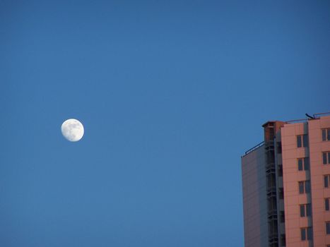 The building shined by light of sunset and the Moon.