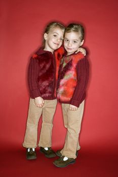 Female children Caucasian twins embrace.