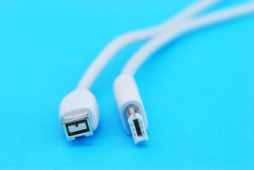 Closeup of white firewire cable on blue