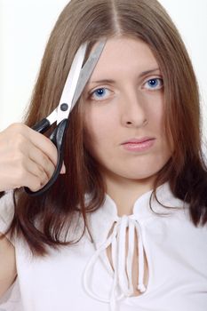 The nice girl holding scissors over an eyebrow